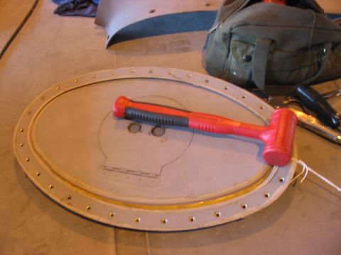 1988 Ford Bronco - A round metal part with a red mallet is shown on a concrete floor.