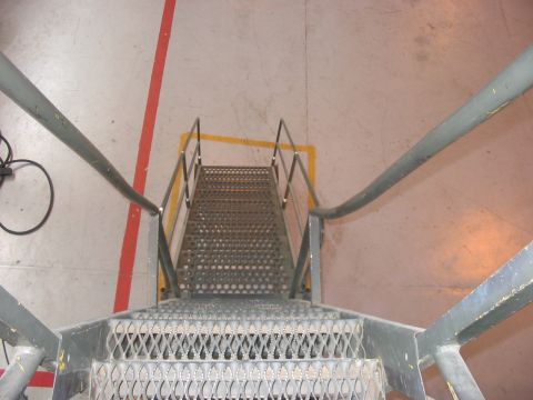 1988 Ford Bronco - Metal staircase with yellow and red floor markings, viewed from above.