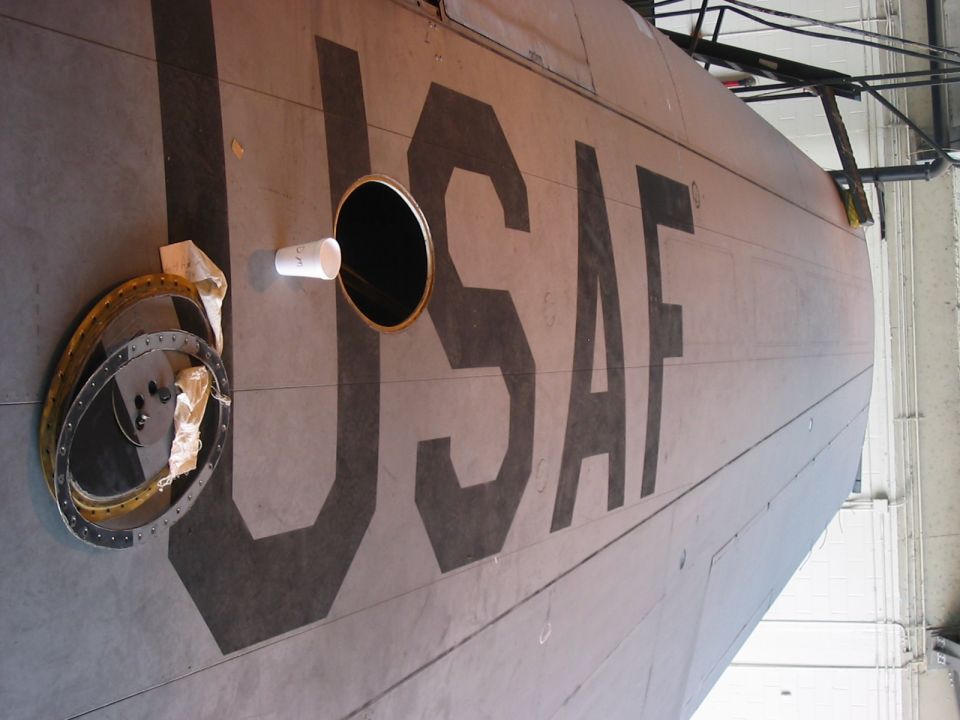 USAF lettering on aircraft fuselage with a circular opening and a detached ring