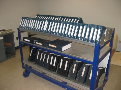 1988 Ford Bronco - A cart filled with binders and books is stored in a room.