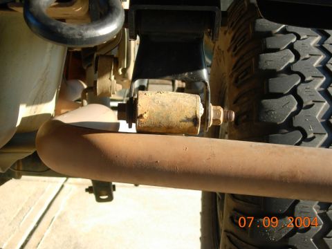 1995 Ford Bronco - Detail shot of the undercarriage, showing an exhaust pipe and a suspension component, with a tire visible.