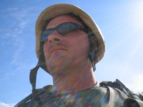 1981 Ford Bronco - A soldier looks up towards the sun, wearing a helmet and sunglasses.