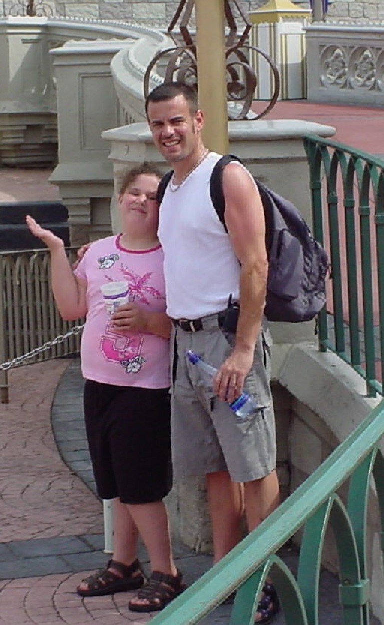 Man and young girl posing together on a theme park bridge