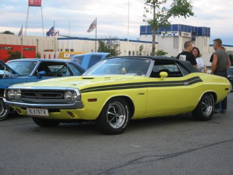 1992 Ford Crown Victoria - A yellow 1970 Dodge Challenger convertible with black racing stripes is parked at an outdoor event.