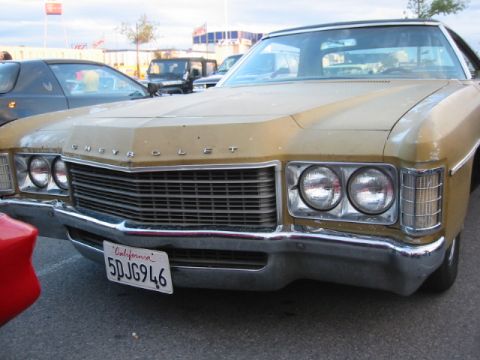 1992 Ford Crown Victoria - A gold Chevrolet sedan is parked next to other vehicles, with a California license plate visible on the front.