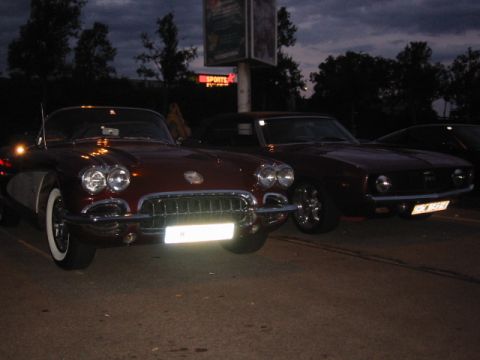 1992 Ford Crown Victoria - Two classic cars are parked together in a lot as the sky darkens.