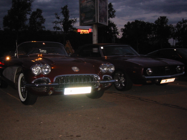 Maroon convertible and another dark car parked side-by-side