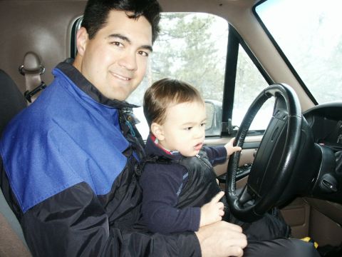 1996 Ford Bronco - Father and child sit in the interior of a 1996 Ford Bronco.