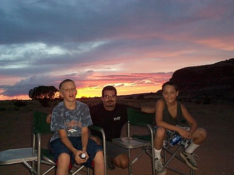 1994 Ford Bronco - A family enjoys the view of a vibrant sunset while camping in a desert environment.