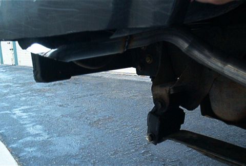 1986 Ford Bronco - The underside of a vehicle shows the exhaust system and rear suspension components.