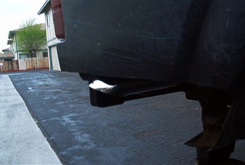 1986 Ford Bronco - Close-up of a vehicle's exhaust pipe tip, showing a shiny metal end.