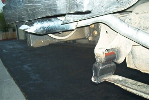 1986 Ford Bronco - Underside view of vehicle exhaust pipe and suspension system components.