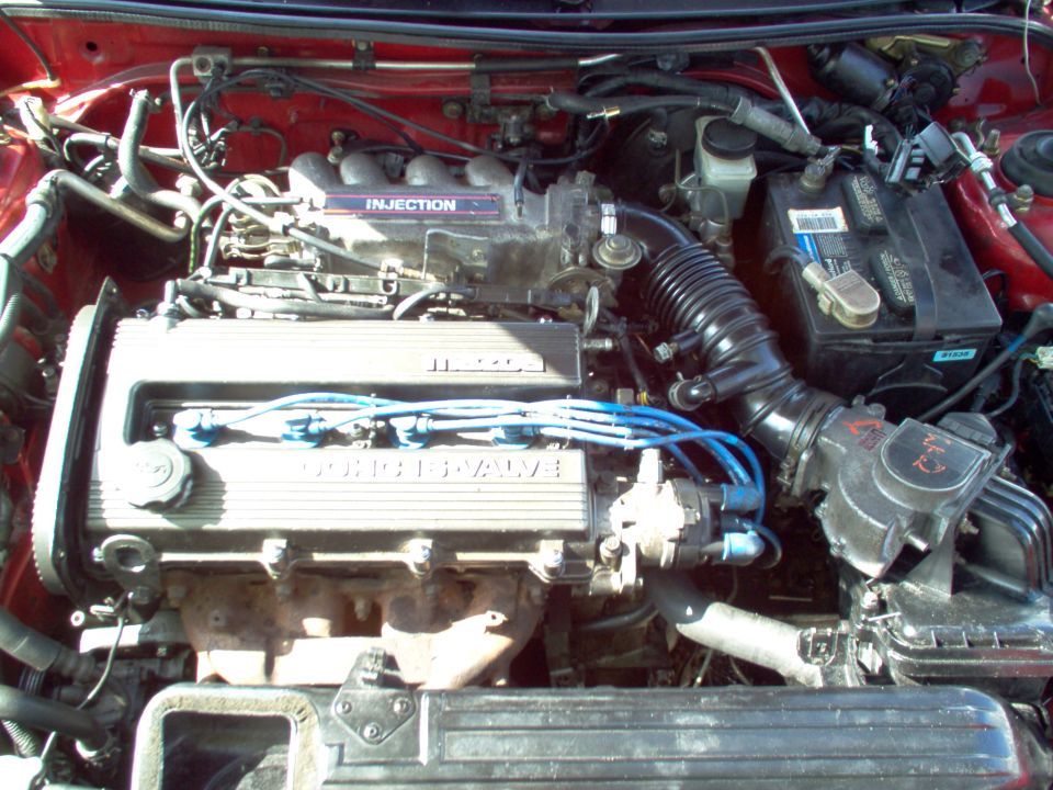 Mazda DOHC 16-valve four-cylinder engine bay with blue spark plug wires