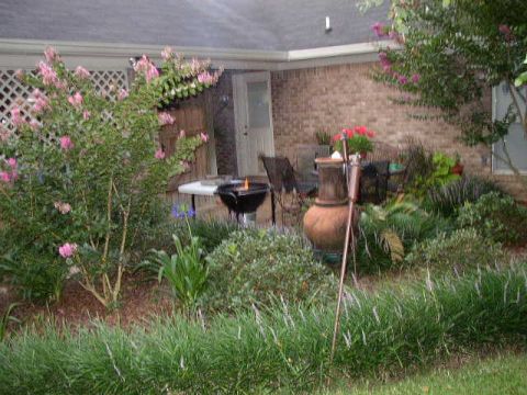 1995 Ford Bronco - A backyard scene a grill, flowering bushes, and decorative elements.