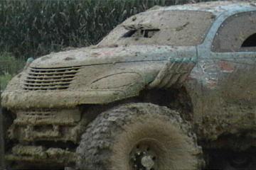 1989 Ford Bronco - This 1989 Ford Bronco is heavily covered in mud, obscuring most details but the grille is still visible.