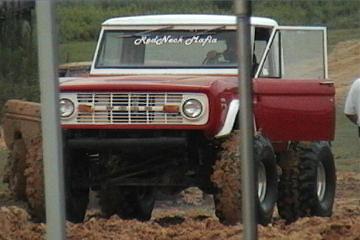 1989 Ford Bronco - This red Ford Bronco is stuck in the mud with its doors open.