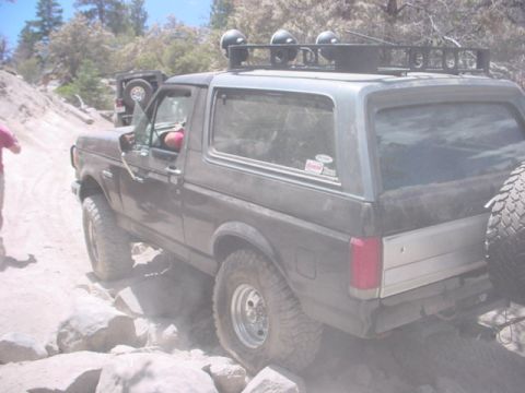 1988 Ford Bronco - This Ford Bronco is navigating a rocky trail with another vehicle visible in the background.