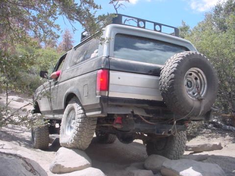 1988 Ford Bronco - This 1988 Ford Bronco navigates a rocky trail, its rear-mounted spare tire and capabilities.