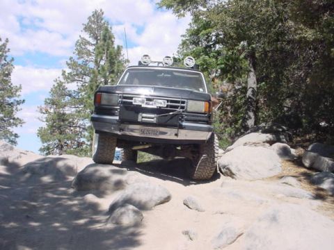 1988 Ford Bronco - This 1988 Ford Bronco navigates a rocky trail, equipped with auxiliary lights on its roof.