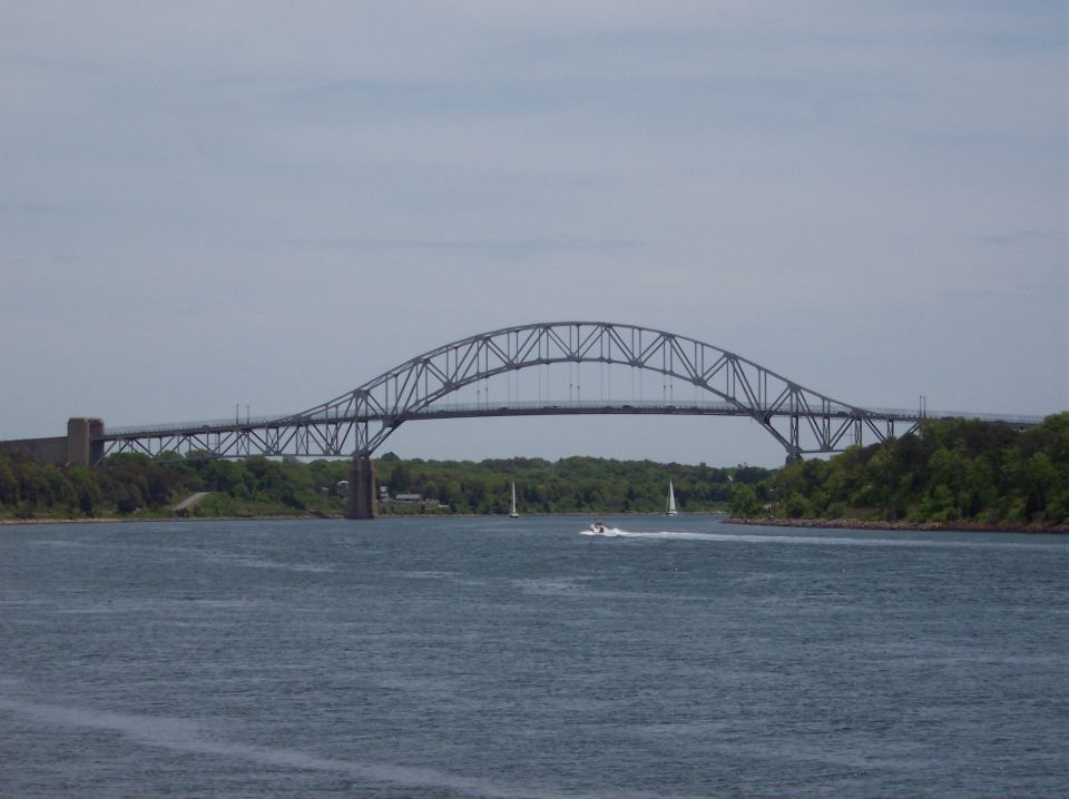 Bridge over water with a speed boat and sailboats