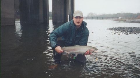 1996 Ford Bronco - A man proudly displays his catch while standing in a river beneath a concrete bridge.