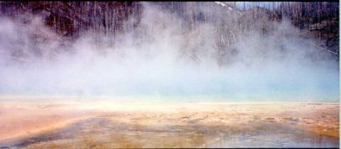 1996 Ford Bronco - A steaming geothermal landscape with mineral deposits creating colorful patterns on the ground.