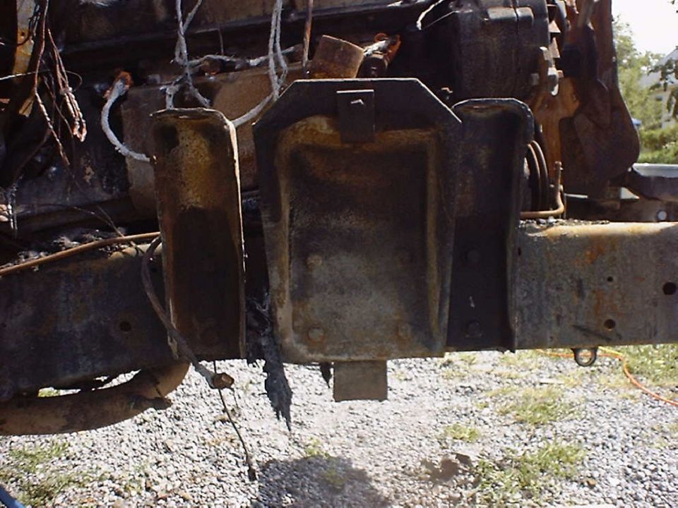 Burnt vehicle frame with engine parts visible. Some wiring is frayed