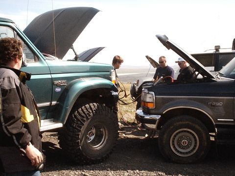 1996 Ford Bronco - Two trucks, a 1996 Ford Bronco and an F-250, are being jumped with jumper cables.