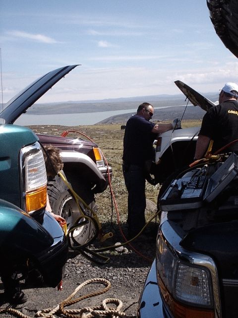 1996 Ford Bronco - Multiple vehicles are being jump-started in a scenic outdoor location.