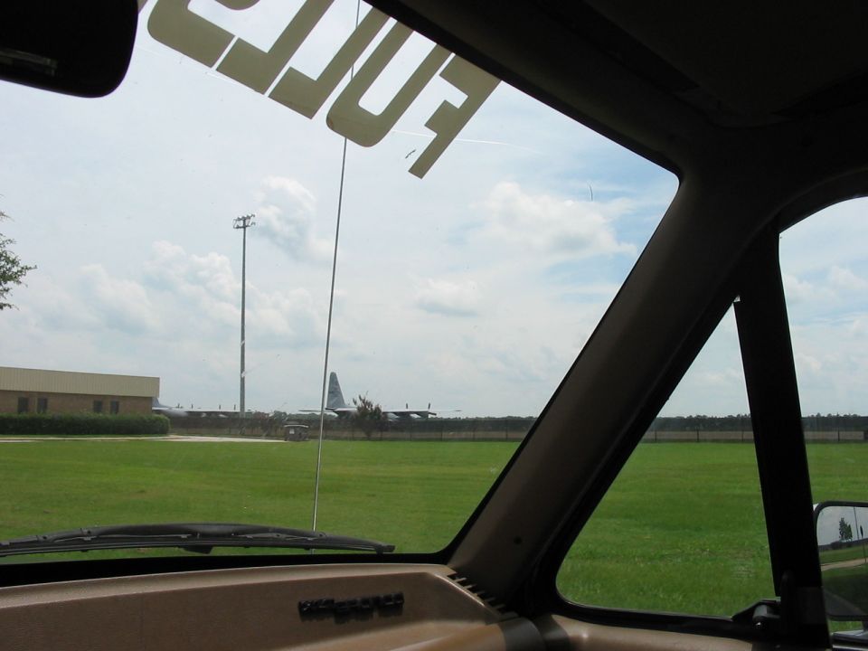 Interior view from a vehicle looking out at an airport with a cargo plane on the tarmac