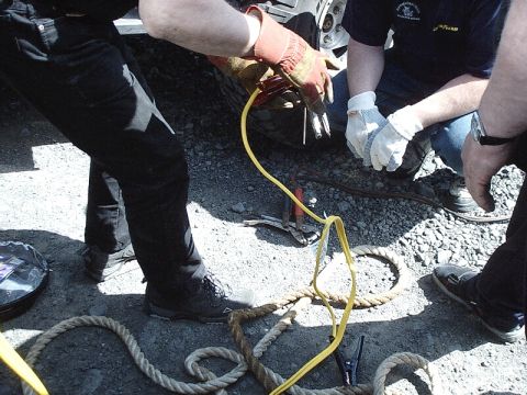 1996 Ford Bronco - People are working on the tire of a 1996 Ford Bronco, attaching jumper cables.