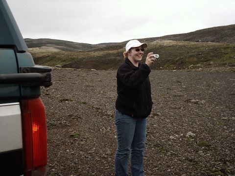 1996 Ford Bronco - A person stands in a rocky landscape, holding a camera and taking a photo.