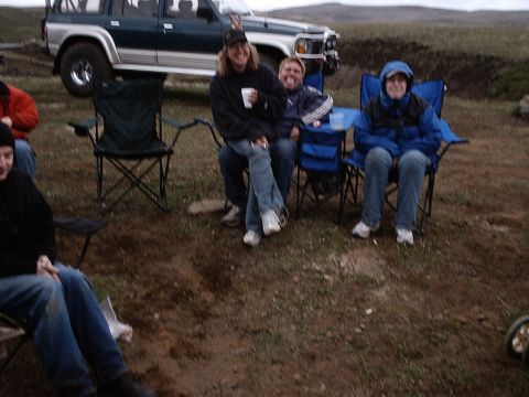 1996 Ford Bronco - A group of people are gathered outdoors with a green and silver SUV in the background.