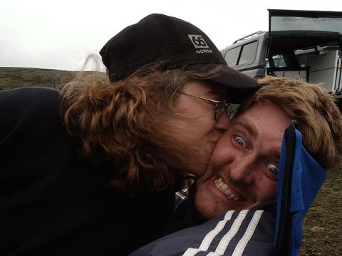 1996 Ford Bronco - A playful moment captured between two friends, with a vehicle in the background.