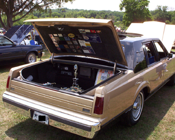 1991 Ford Crown Victoria LTD - A gold 1985 Lincoln Town Car is parked outdoors with its trunk open, displaying various stickers and a trophy.