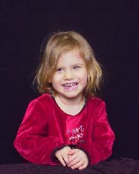 1995 Ford Bronco - A young girl with blonde hair smiles while wearing a red dress against a dark background. The Supermotors logo is visible at the bottom.