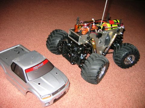 1985 Ford Bronco - A disassembled remote control monster truck sits on a carpeted surface.