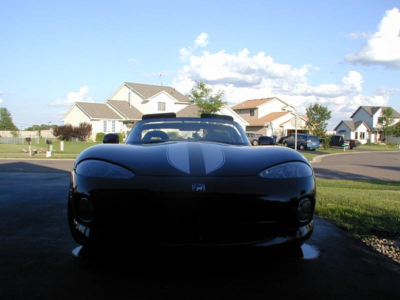 Black Dodge Viper roadster with silver stripes, front view in a suburban driveway