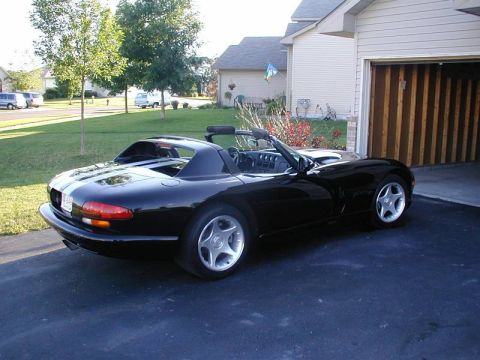 1996 Dodge Viper - A black 1996 Dodge Viper convertible is parked in a driveway next to a garage.