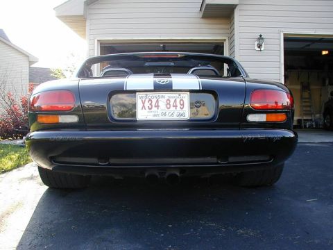 1996 Dodge Viper - Rear view of a black convertible with dual racing stripes and dual exhaust pipes.