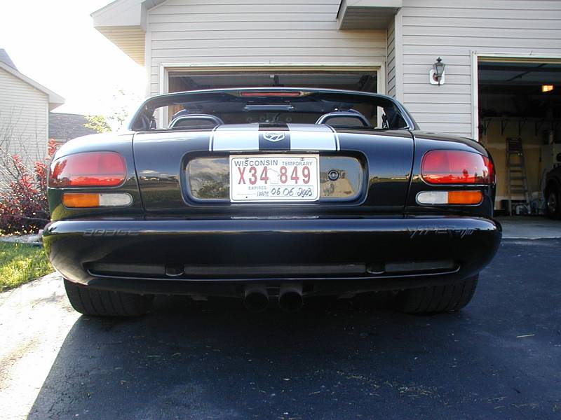 Rear view of black Dodge Viper roadster with silver stripes and center-exit exhaust