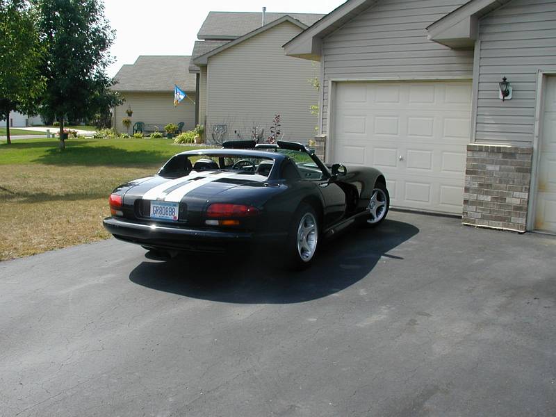 Black Dodge Viper RT/10 roadster with white stripes, rear three-quarter view in a driveway