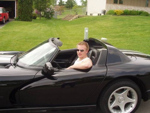 1996 Dodge Viper - Man driving a black 1996 Dodge Viper convertible on a sunny day.