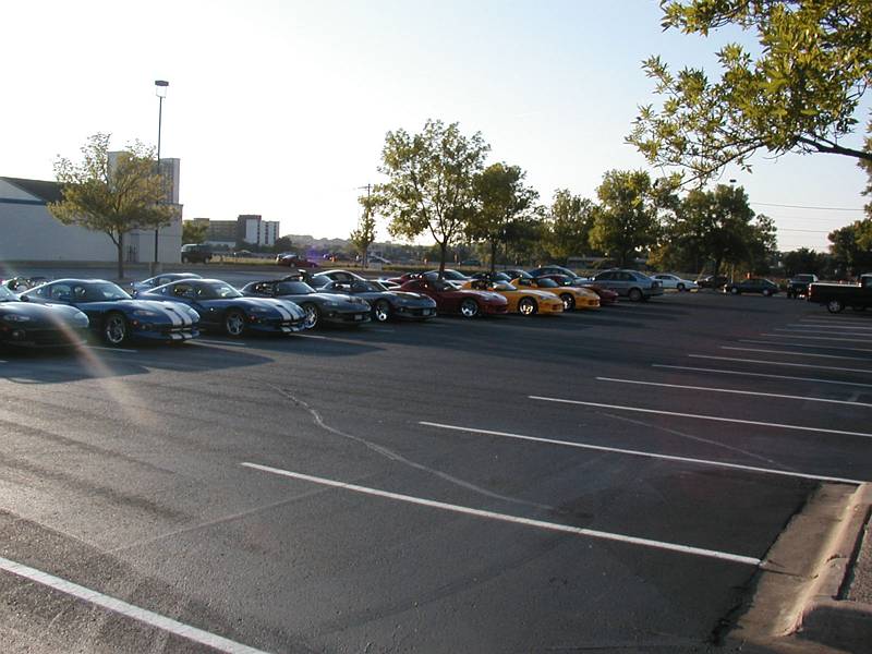 Row of sports cars including Vipers parked in a lot at sunset