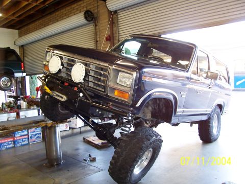 1985 Ford Bronco - This 1985 Ford Bronco is undergoing modifications in a garage, with its front end raised on a lift.
