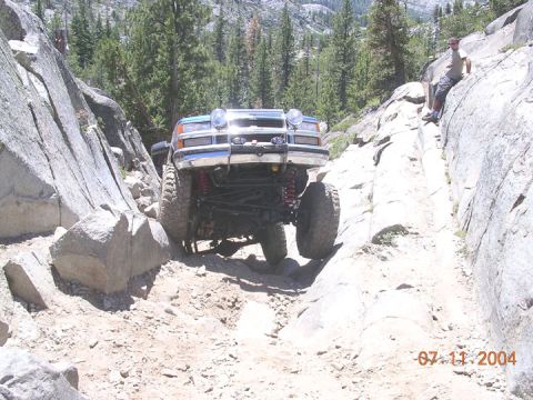 1994 Ford Bronco - A modified truck navigates a challenging rocky path in a mountainous area.