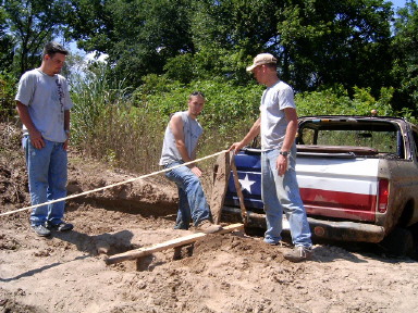 1978 Ford Bronco - Three men work to extract a vehicle from a sandy, overgrown area.
