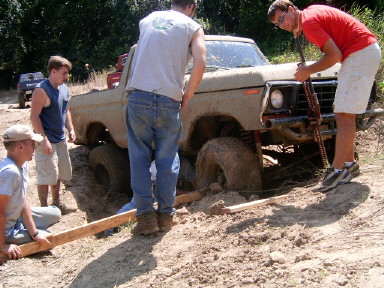 1978 Ford Bronco - Four men attempt to free a mud-covered 1978 Ford Bronco from a ditch.