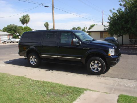 2004 Ford Excursion - Side view of a black 2004 Ford Excursion parked on a sunny day.