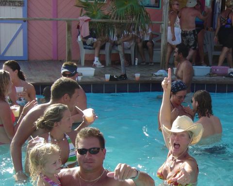 1993 Ford Bronco - A group of people enjoy drinks in a swimming pool, with one woman in a cowboy hat making a gesture.